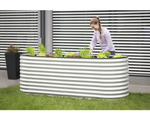 Jardinière surélevée en métal avec des plantes et une femme qui travaille à l''intérieur