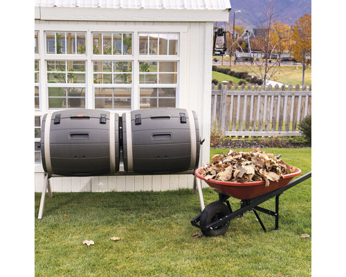 Double composteur à côté d''une brouette pleine de feuilles dans le jardin