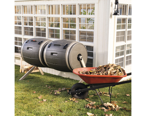 Double composteur et brouette avec des feuilles dans le jardin