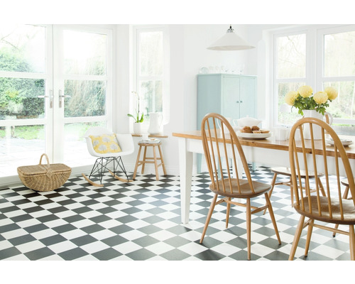Salle à manger lumineuse avec sol à damier, table en bois, chaises et fenêtres pour un éclairage naturel