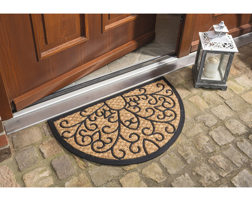 Halbrunde Fussmatte aus Kokosfaser mit floralem Muster vor einer Haustür