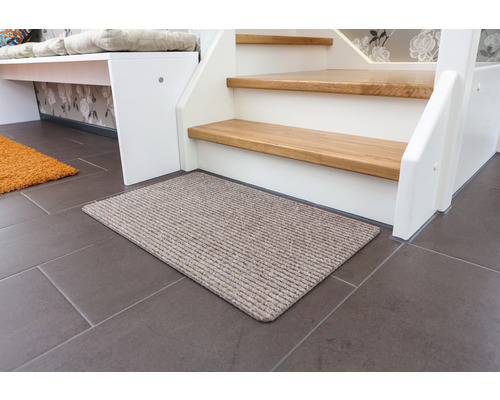 Paillasson devant un escalier sur un sol carrelé