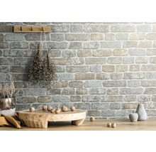 Wandgestaltung mit Steinoptik, Holzbrett, Dekoration und Nüssen auf Holztisch