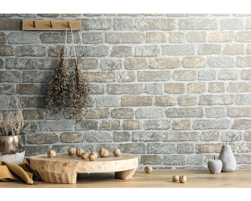 Wandgestaltung mit Steinoptik, Holzbrett, Dekoration und Nüssen auf Holztisch