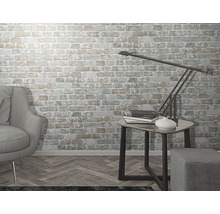 Wohnzimmer mit Ziegelwandtapete, Sessel, Beistelltisch und Lampe