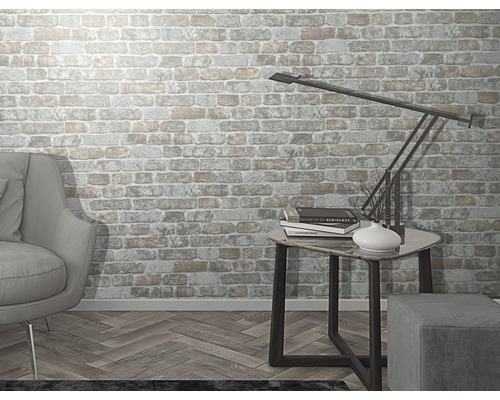 Wohnzimmer mit Ziegelwandtapete, Sessel, Beistelltisch und Lampe