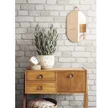 Pièce décorative avec papier peint imitation briques, miroir et commode