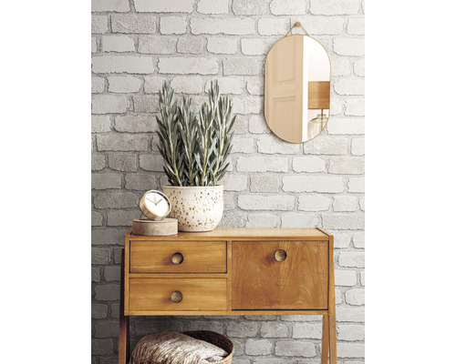 Pièce décorative avec papier peint imitation briques, miroir et commode