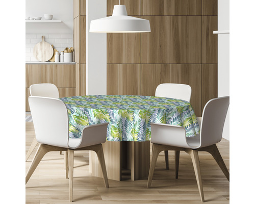 Esstisch mit runder Tischdecke mit Blattmuster in einem Esszimmer.