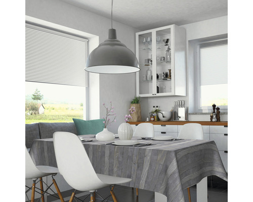 Salle à manger lumineuse avec table, chaises, suspension et fenêtre avec stores.