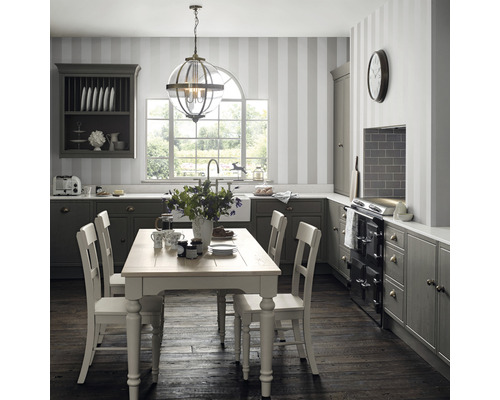 Cuisine classique avec table à manger, chaises, suspension et armoires de cuisine.