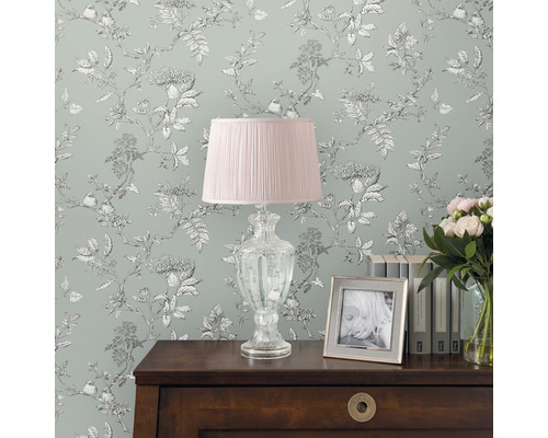 Pièce décorative avec papier peint à fleurs, lampe de chevet, livres et bouquet