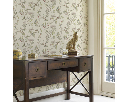 Bureau décoratif avec bureau, papier peint à motif végétal et sculpture de léopard.