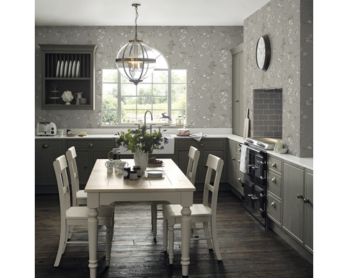 Cuisine lumineuse avec table à manger, chaises, armoire suspendue et papier peint à motifs floraux