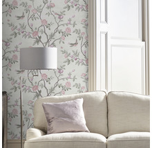 Salon avec papier peint à motifs floraux, canapé et lampadaire