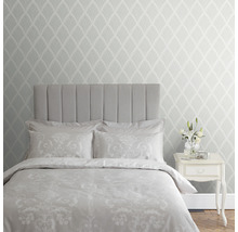 Chambre avec lit, table de chevet et papier peint à motifs