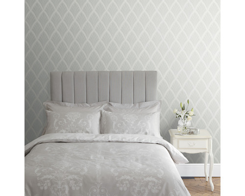 Chambre avec lit, table de chevet et papier peint à motifs