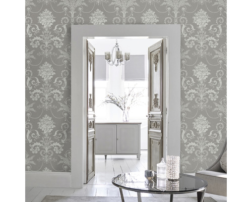 Salon avec papier peint à motifs gris, vue à travers une porte sur une autre pièce