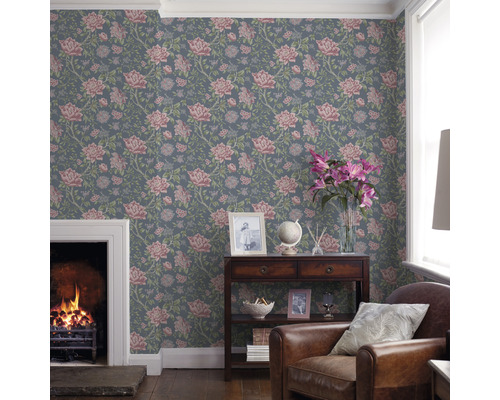 Salon avec papier peint à motifs floraux, cheminée et fauteuil