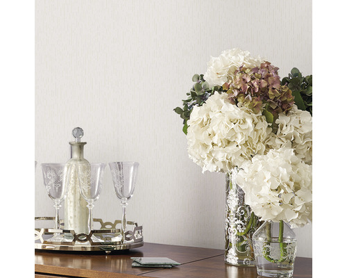 Arrangement décoratif avec des fleurs, une carafe et des verres sur une table