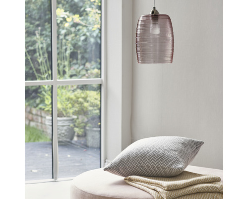 Scène avec suspension en verre, coussin et couverture sur un tabouret près d''une fenêtre