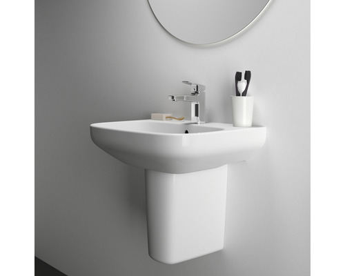 Weisses Waschbecken mit Armatur, Zahnputzbecher und Spiegel an einer Wand montiert.