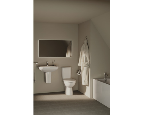 Badezimmer mit Waschtisch, Toilette, Spiegel und Badewanne