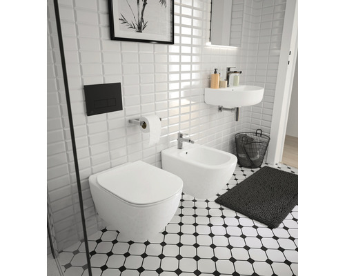 Helles Badezimmer mit Toilette, Bidet, Waschbecken und schwarz-weiss gemusterten Fliesen