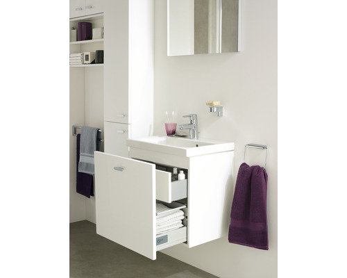 Badezimmer mit Waschbeckenunterschrank, Spiegelschrank und Handtuchhaltern für die Badtextilien.