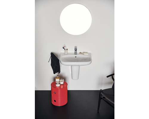 Badezimmer mit rundem Spiegel, Waschbecken und rotem Schrank