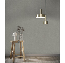 Innenraum mit strukturierten Tapeten, Hocker mit Dekoration und Deckenleuchte