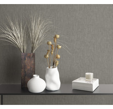 Dekorative Elemente auf einem Tisch: Vasen, Trockenblumen, Buch und Kerze.