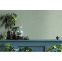 Dekorative Szene mit Pflanzen, Terrarium und Pflanzensprüher auf einem Regal vor einer strukturierten Wand