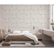 Helles Schlafzimmer mit floraler Tapete, Bett und Nachttischen