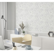 Bureau avec bureau, chaise, lampe et un mur avec du papier peint à motifs floraux