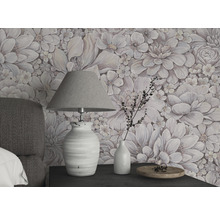 Espace de vie avec papier peint à fleurs, lampe de table et décorations sur une table de chevet