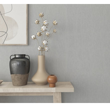 Dekorative Vasen auf einem Holztisch vor einer grauen Wand