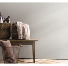 Dekorative Szene mit Körben und Textilien auf einem Holztisch vor einer Wand