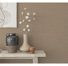 Dekorative Vasen und ein Bild auf einem Tisch vor einer beigen Wand