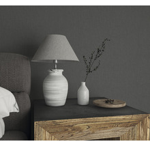 Dekorative Tischleuchte mit Stoffschirm, Vase und Schale auf einem Holztisch