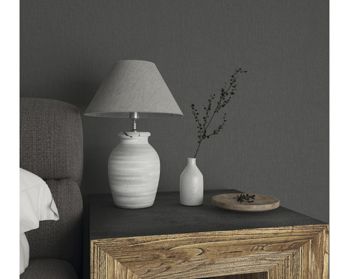 Dekorative Tischleuchte mit Stoffschirm, Vase und Schale auf einem Holztisch