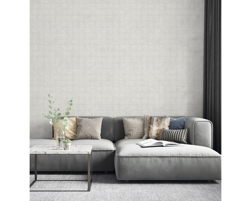 Salon avec canapé gris, coussins et papier peint à motifs pour une ambiance lumineuse et moderne.