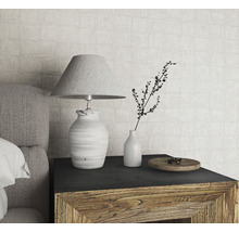 Scène de table de chevet décorative avec lampe, vase et petite assiette