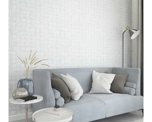 Salon lumineux avec canapé, coussins, tables d''appoint et papier peint à motifs