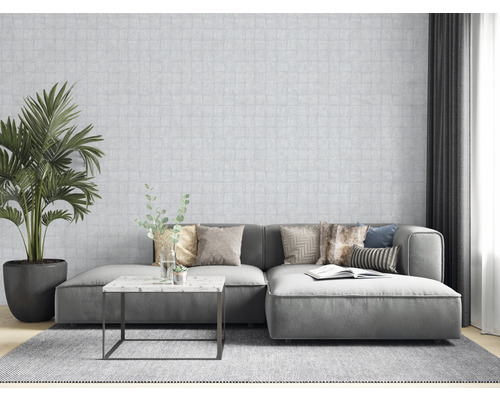 Salon avec canapé, coussins, table, plante d''intérieur et papier peint à motifs