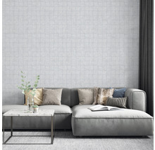 Salon avec papier peint à motifs, canapé, coussins et table