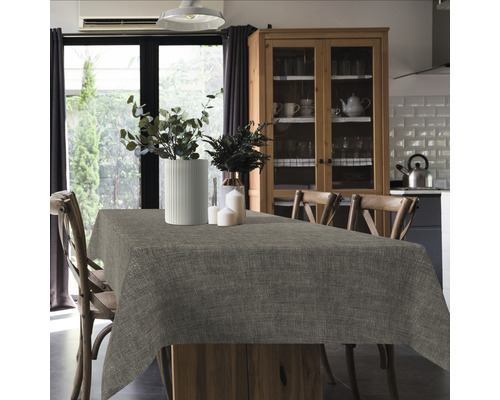 Esstisch mit Tischdecke, Vasen und Kerzen in einem hellen Raum