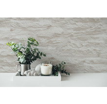 Scène décorative avec bougie, eucalyptus et mur en pierre