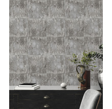 Papier peint gris aspect béton derrière une armoire en bois foncé