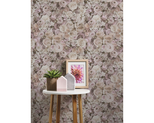 Gros plan d''un mur avec du papier peint à fleurs à motif de roses derrière une petite table avec des décorations.